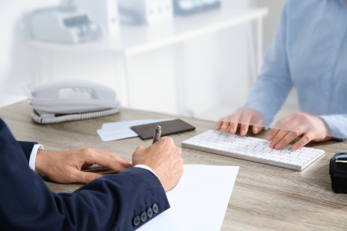 Man,Filling,Blank,At,Cash,Department,Window,,Closeup
